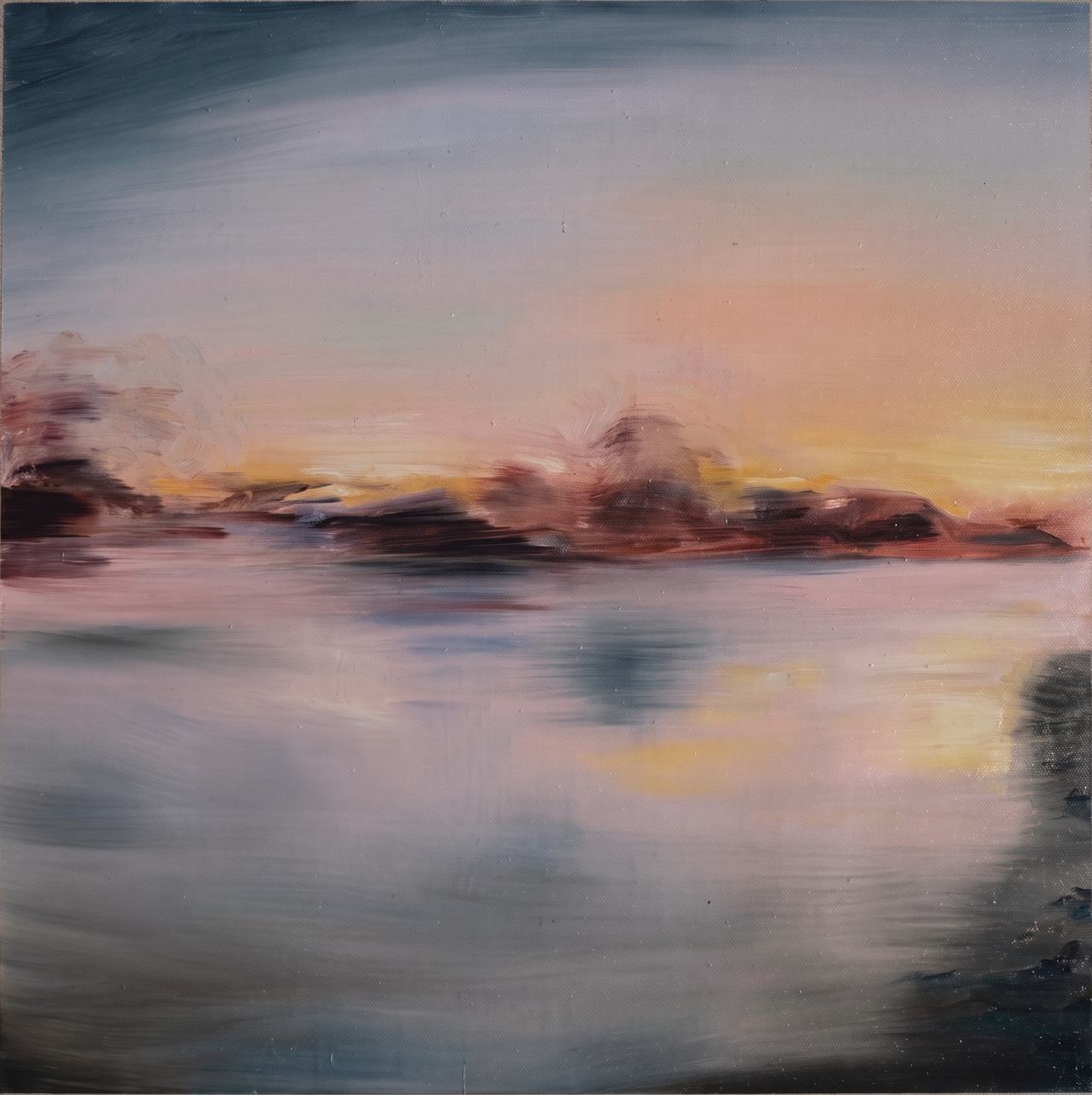 Tonal muted sunset over water with a dark headland and soft reflections.
